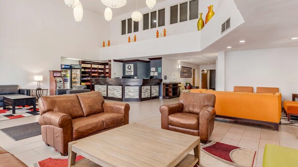 A spacious lobby with leather sofas, a reception desk, and a Pepsi refrigerator. - Quality Inn & Suites Denver Airport - Gateway Park (Aurora)