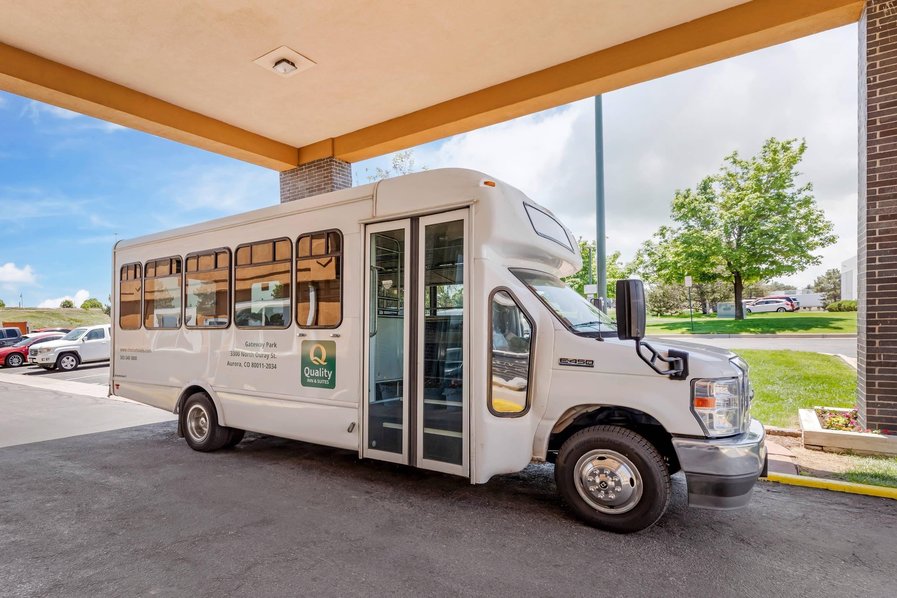 A white mobile hotel with a website address and contact number on the side, parked under a covered area.