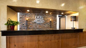 Un mostrador de recepción con pared de piedra y encimera de madera.