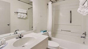 A modern bathroom with a sink, toilet, and bathtub. - Baymont by Wyndham Loveland/Fort Collins Area (Loveland)