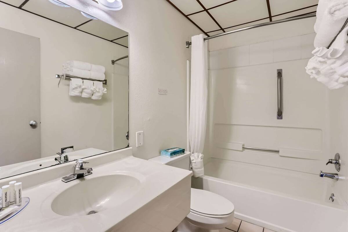 A bathroom with a sink, toilet, and shower.