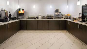 A modern kitchen with a central island, equipped with a coffee machine, toaster, and a fruit bowl.