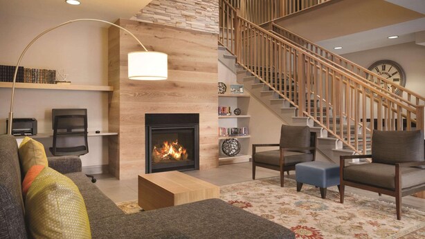Un salon moderne avec une cheminée, un escalier et un coin salon confortable.