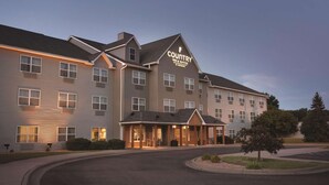 Un hôtel Country Inn & Suites doté d’une entrée principale, de nombreuses fenêtres et d’une allée aménagée.
