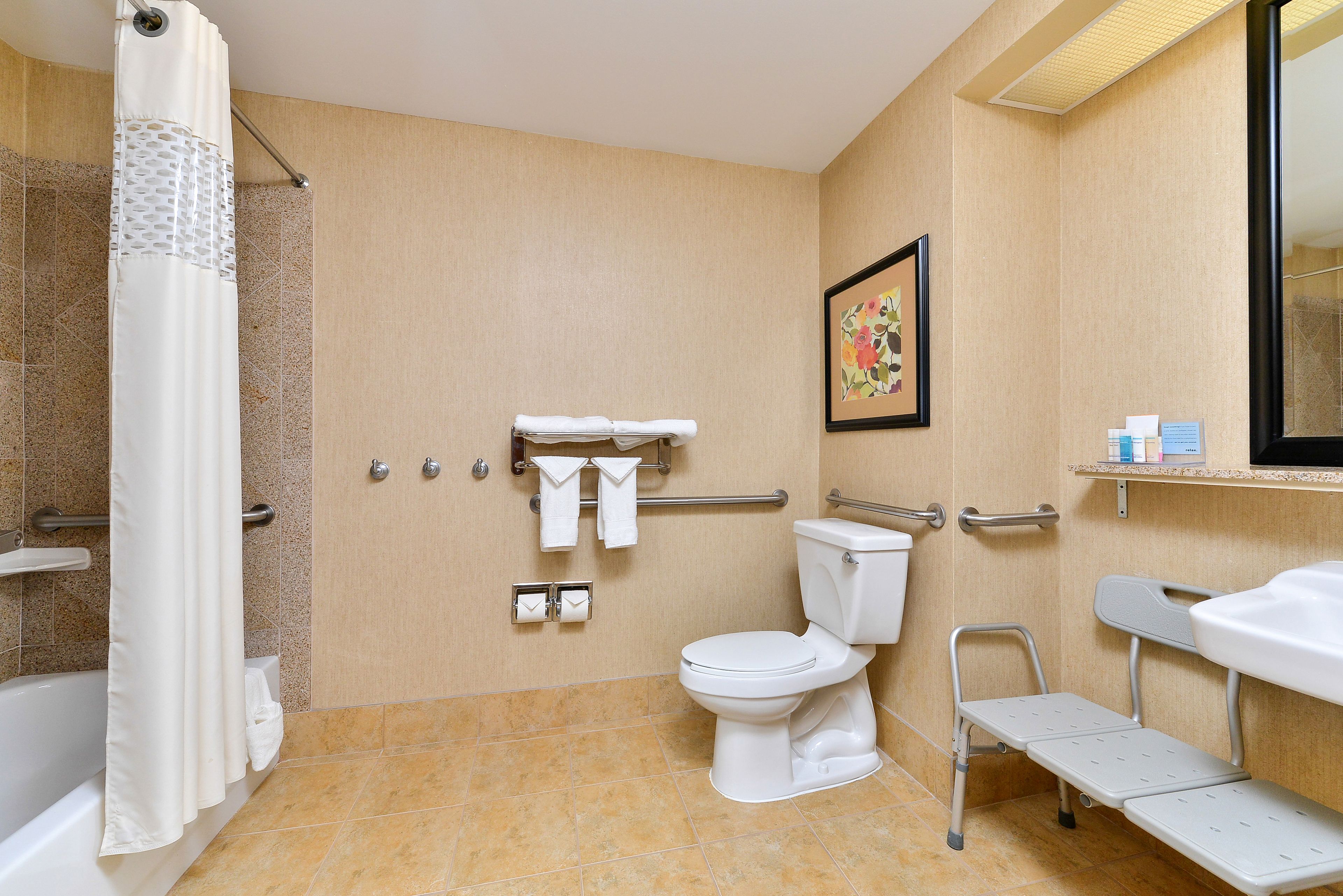 A bathroom with a shower, toilet, and a sink.
