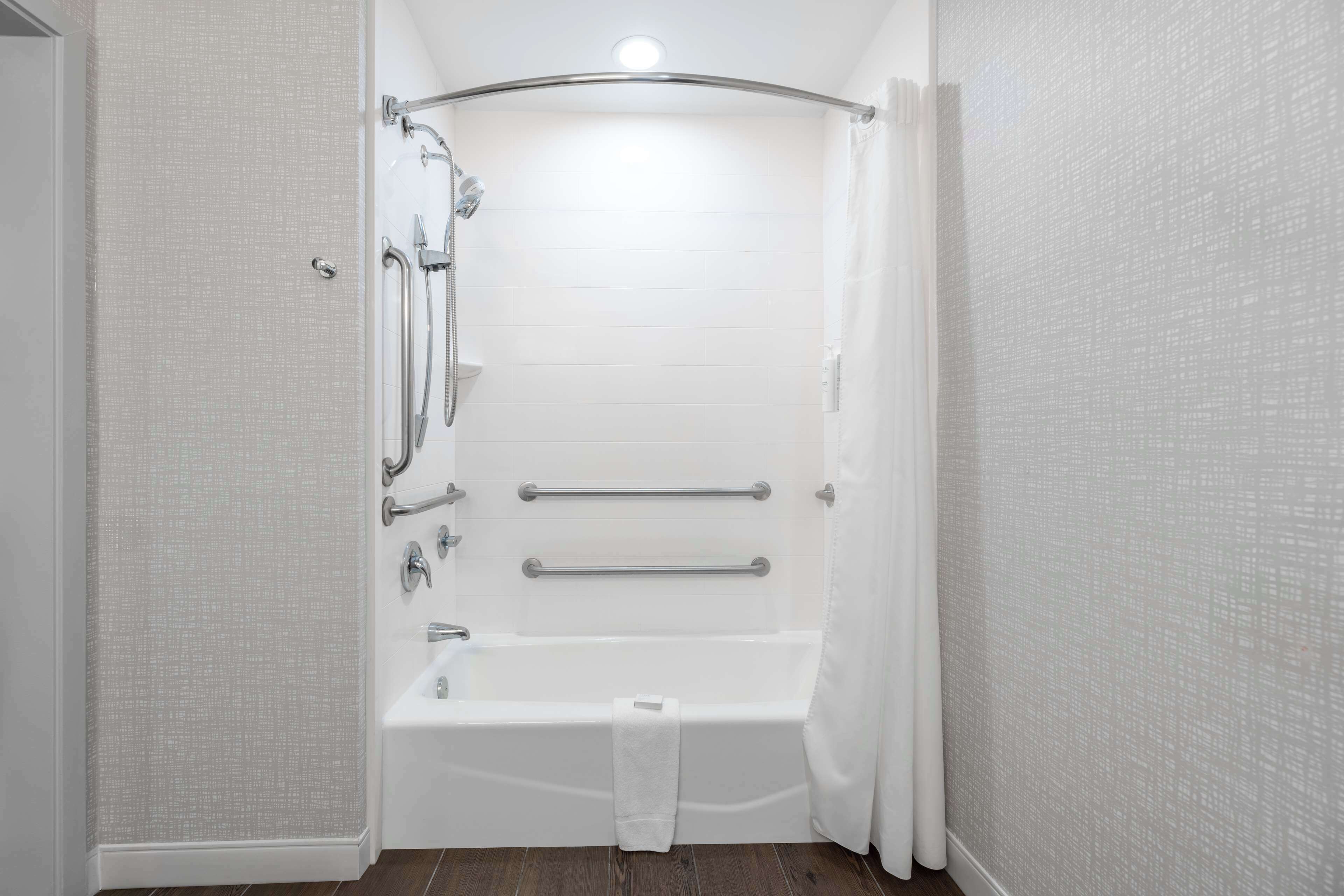 A bathroom with a shower, a bathtub, and a toilet.