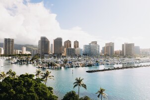 A marina with numerous boats and a city skyline in the background.