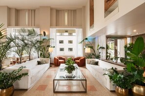 A spacious lobby with a central coffee table, seating area with sofas, and potted plants. - Eurostars Winter Haven (Miami Beach)