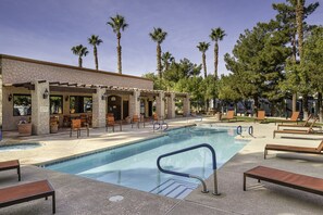 A pool area with lounge chairs, a covered seating area, and palm trees. - Arizona Charlie's Boulder (Las Vegas)