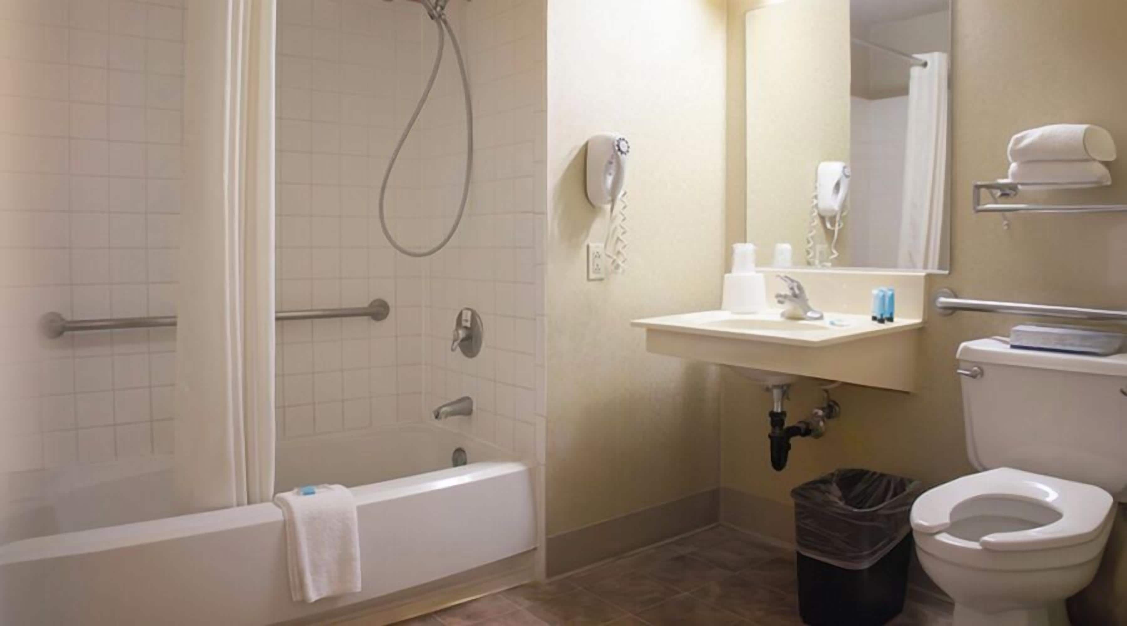A bathroom with a bathtub, a toilet, a sink, and a mirror.