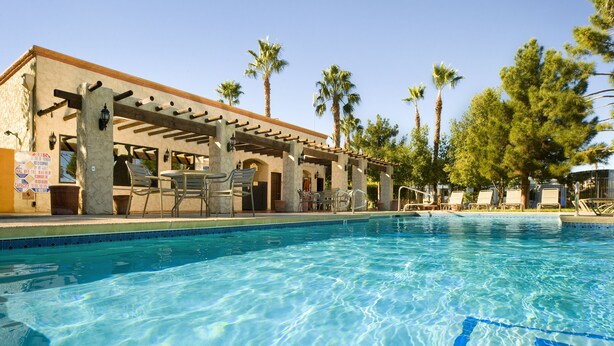 Ein Poolbereich mit Liegestühlen und einer Pergola.