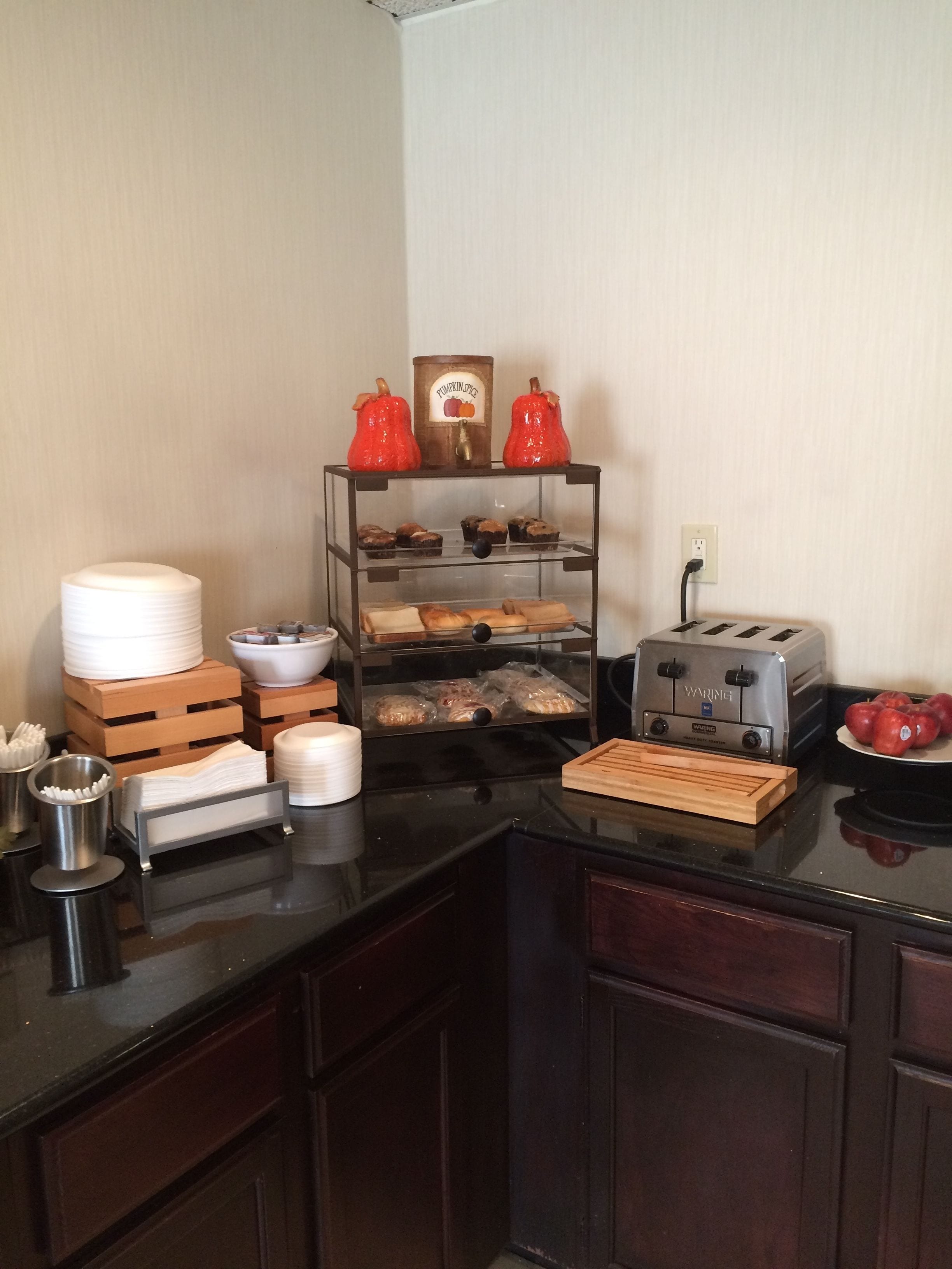 A kitchen counter with a toaster, a coffee maker, and a fruit bowl.