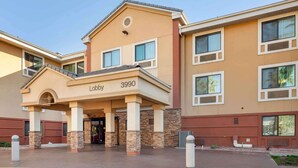 A hotel entrance with a prominent lobby area, numbered 3990, featuring a beige facade with stone accents and multiple windows.