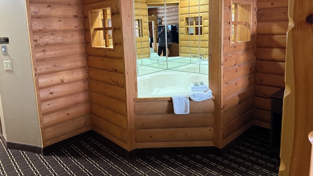 A wooden cabin with a glass-enclosed shower area, a visible towel, and a tiled floor. - Best Western Dodgeville Inn & Suites (Dodgeville)