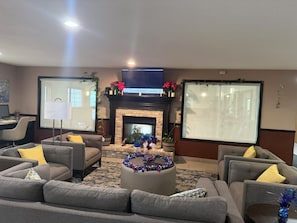 A living room with a fireplace, two sofas, a coffee table, and a TV.