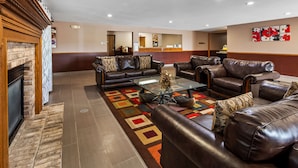 A spacious lobby with leather sofas, a glass coffee table, and a fireplace. - Best Western Dodgeville Inn & Suites (Dodgeville)