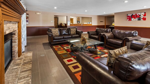 A spacious lobby with leather sofas, a glass coffee table, and a fireplace. - Best Western Dodgeville Inn & Suites (Dodgeville)