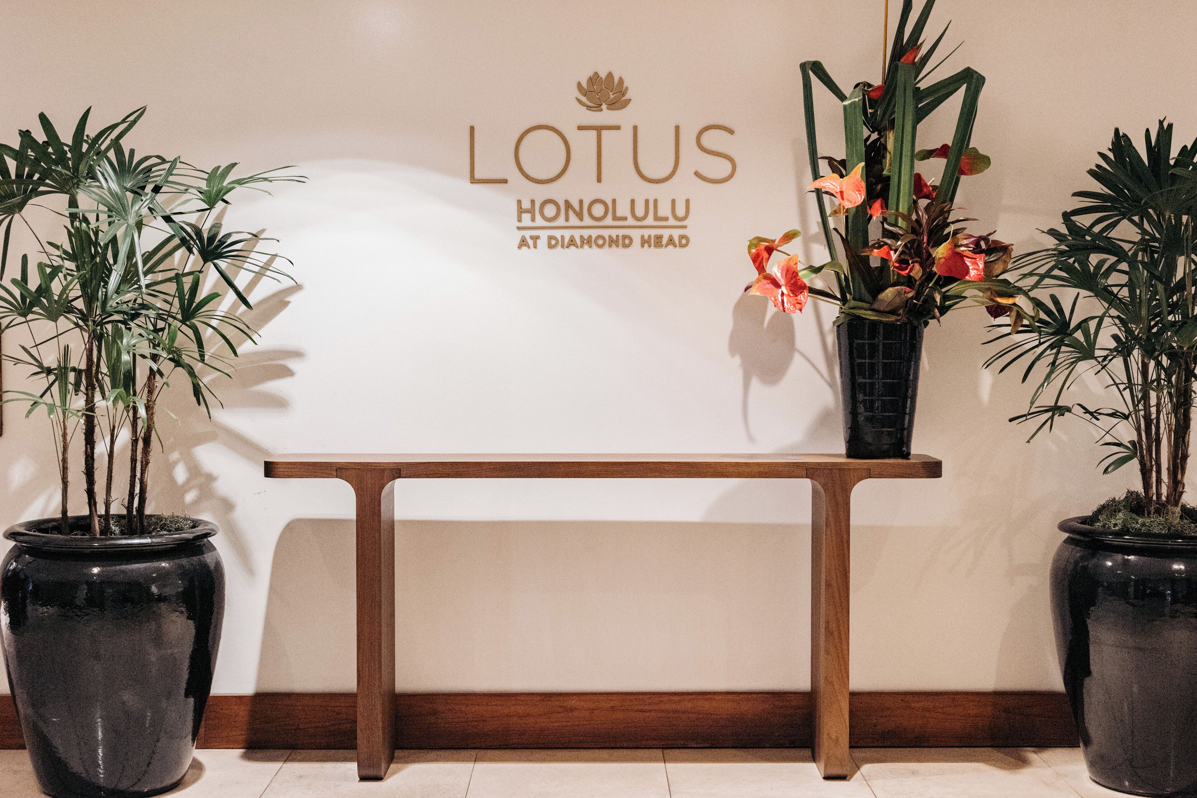 Ein Empfangstresen mit dem Schild 'LOTUS HONOLULU AT DIAMOND HEAD'.