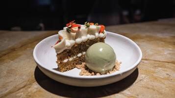 Un postre con una bola de helado sobre un plato.