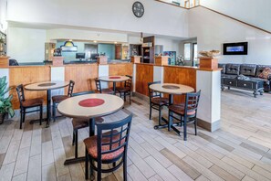 Relax in our spacious lobby with comfortable seating areas, round tables, and a reception desk.