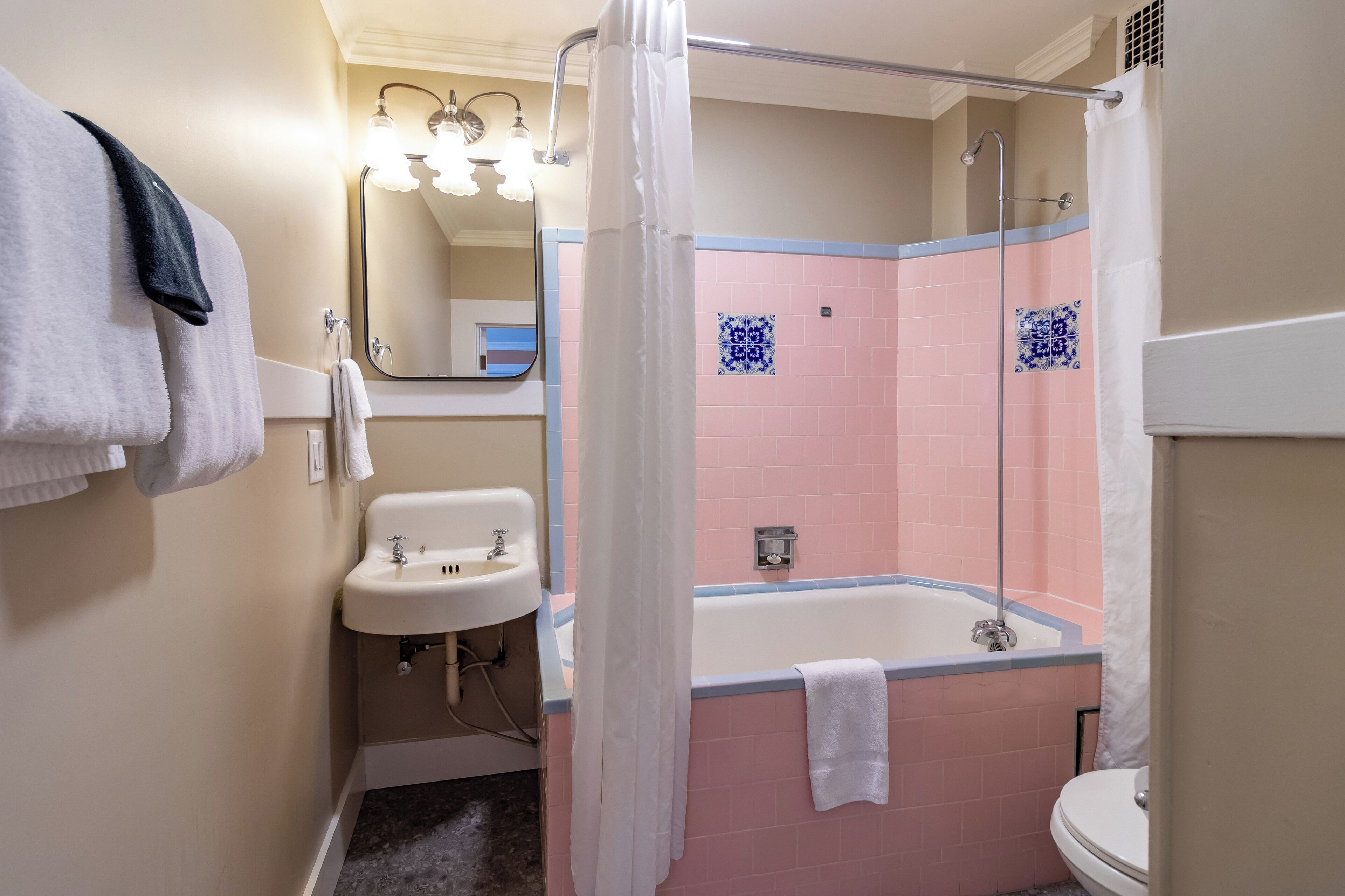 A bathroom with a sink, a bathtub, and a shower curtain.