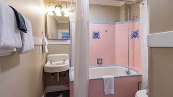 A bathroom with a sink, a bathtub, and a shower curtain.