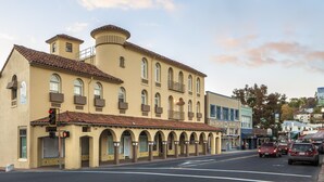 A historic building with a tiled roof, multiple windows, and a balcony.