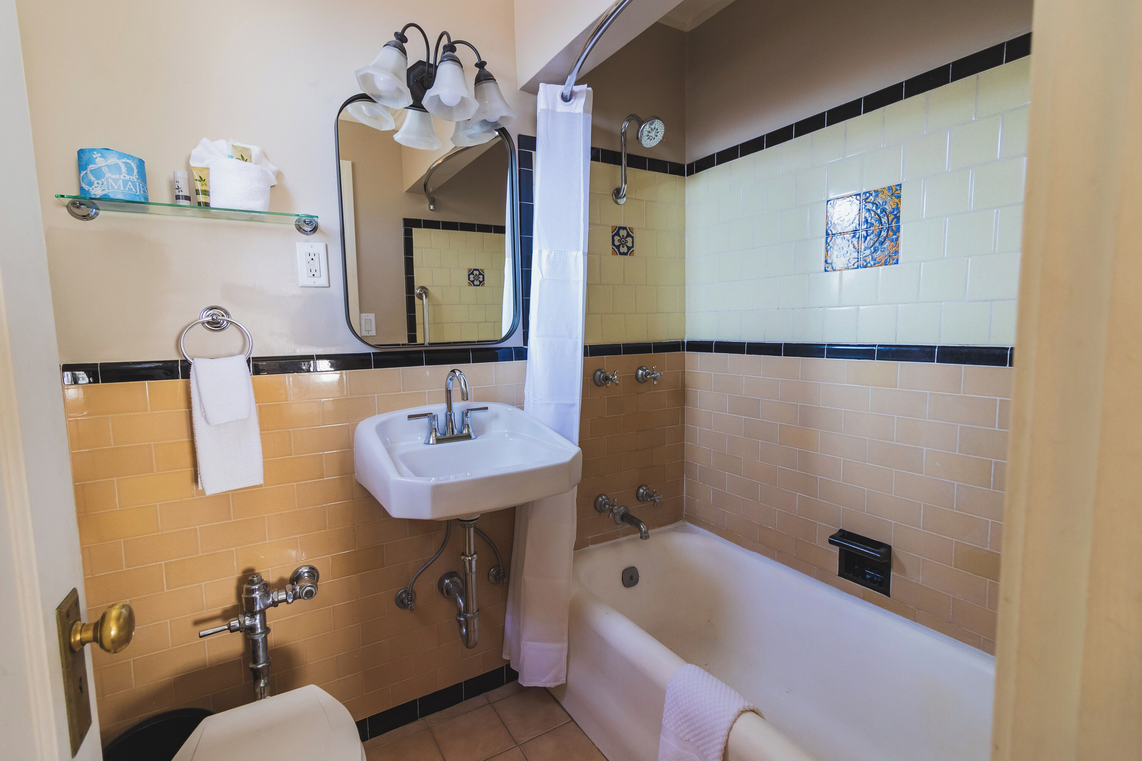 A bathroom with a bathtub, a sink, a mirror, and a shower curtain.