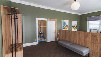 Cozy retreat with a wooden bench, shelving unit, and framed artwork, offering a peaceful atmosphere.