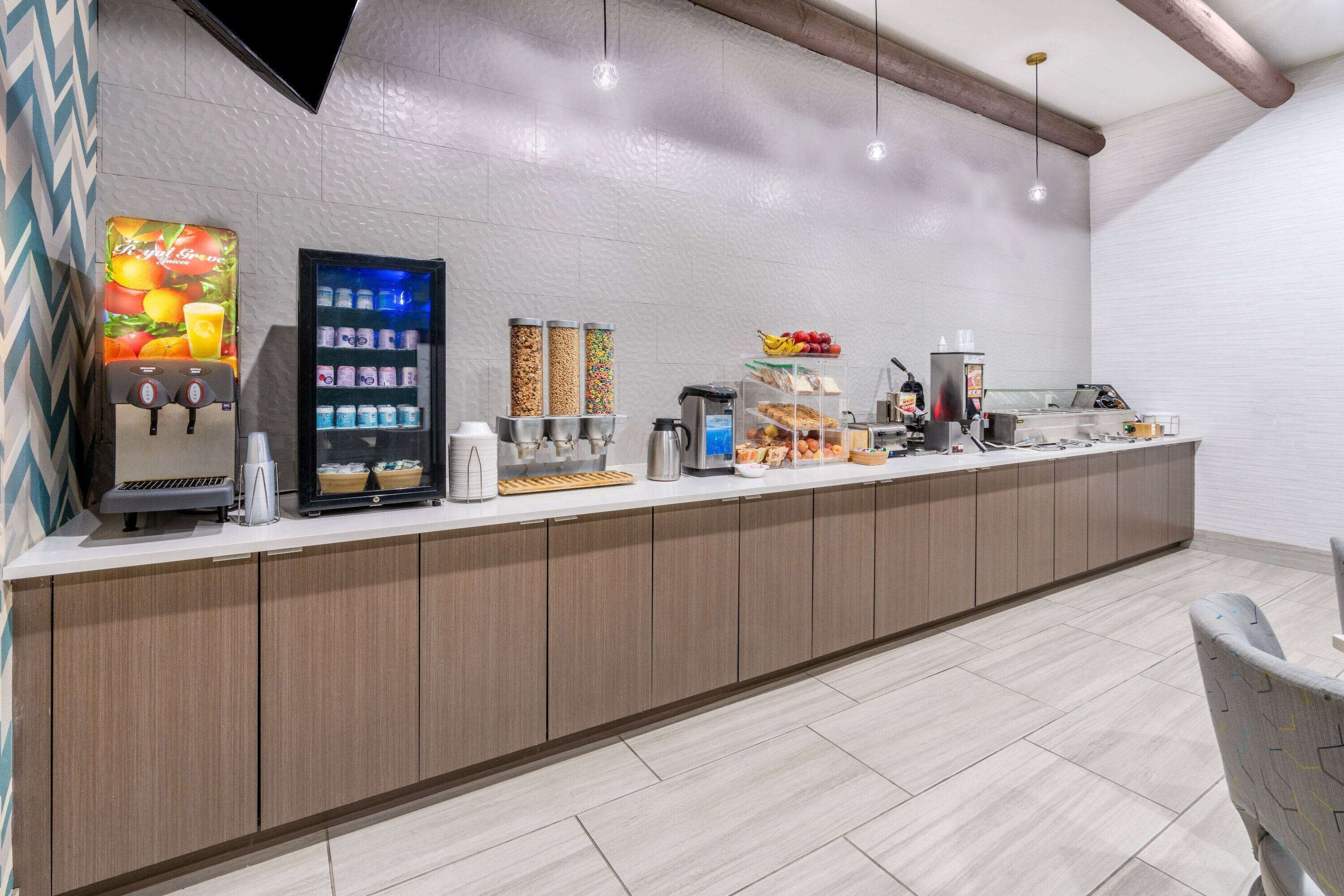 A modern breakfast bar with a vending machine, refrigerated drinks, and a coffee station.
