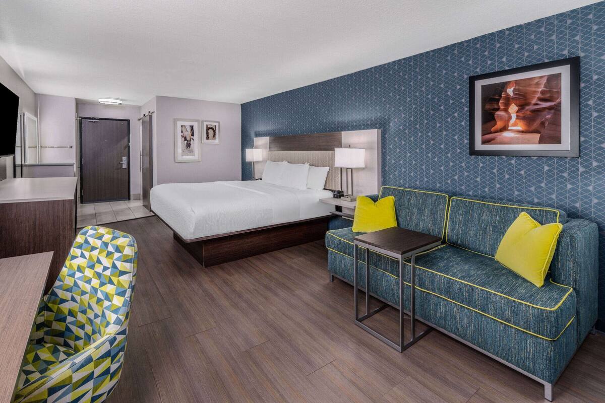 Een hotelkamer met een bed, een bank, een bureau en een stoel.