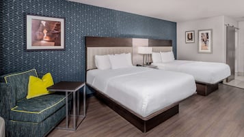 A hotel room with a large bed, a sofa, and a small table.