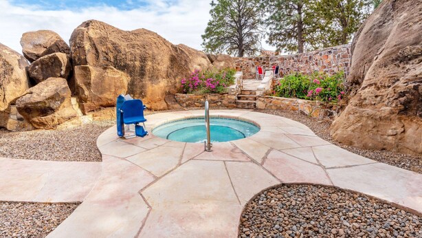 A swimming pool with a stone deck, surrounded by large rocks and trees. - La Quinta Inn & Suites by Wyndham Santa Rosa (Santa Rosa)