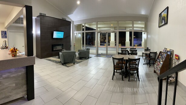 En rymlig entréhall med en öppen spis, en sittgrupp och en receptionsdisk.