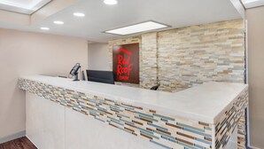 Una recepción de hotel con diseño moderno, un teléfono digital y un cartel de Red Roof Inn.