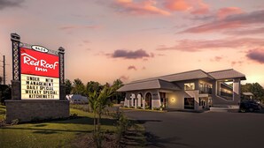 Ein Red Roof Inn mit großer Schautafel, ein zweistöckiges Gebäude und ein Parkplatz.