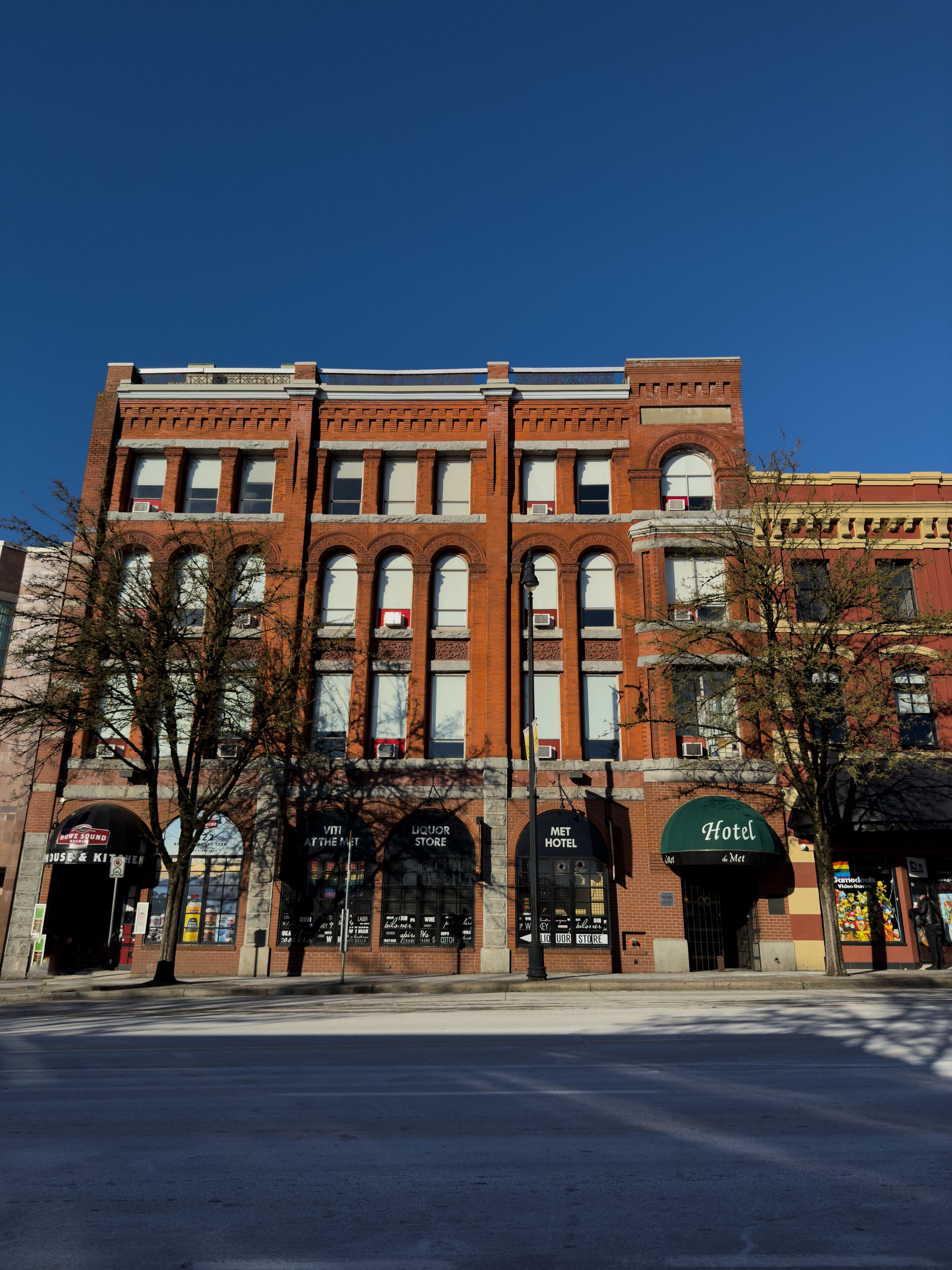 A historic building with multiple storefronts, including a liquor store, a hotel, and a music venue.