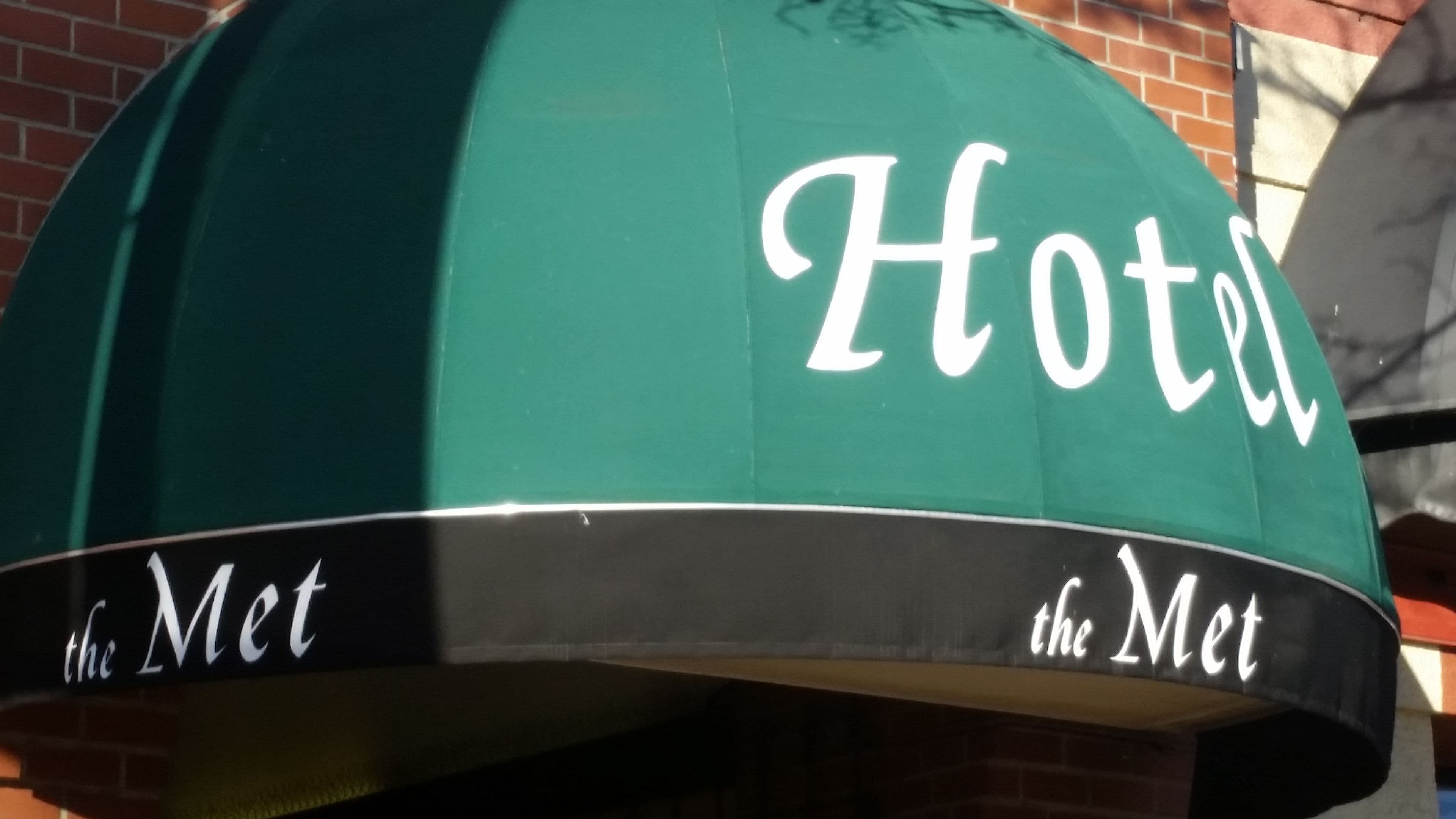 A green awning with the words "Hotel the Met" written on it.