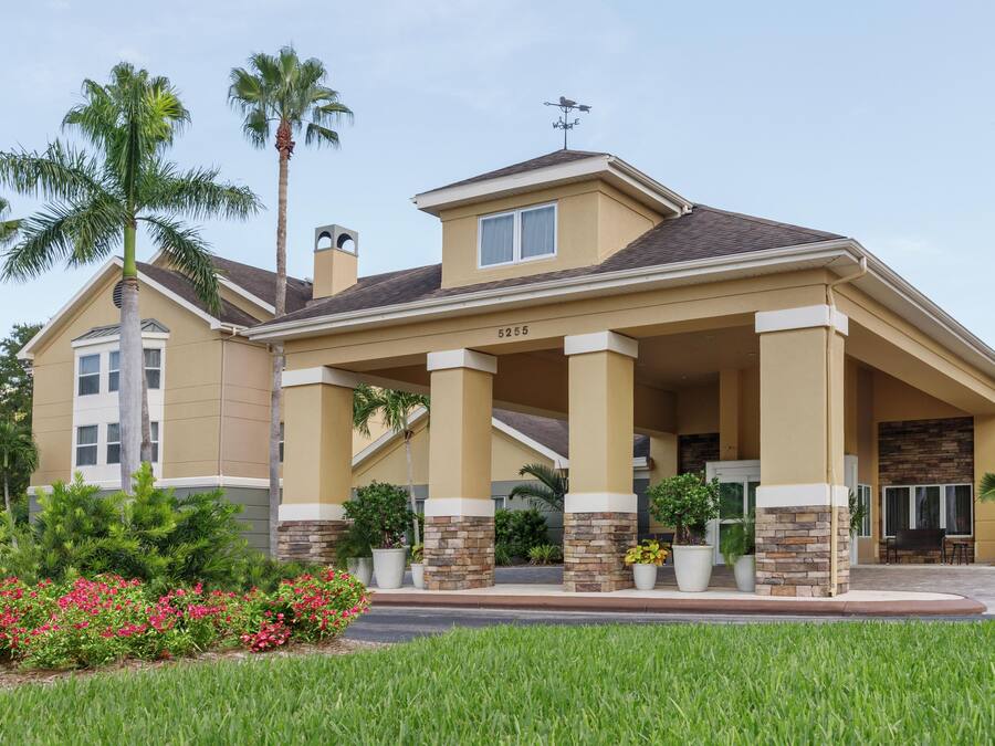 A two-story house with a covered porch, stone pillars, and a number '5255' on the front.