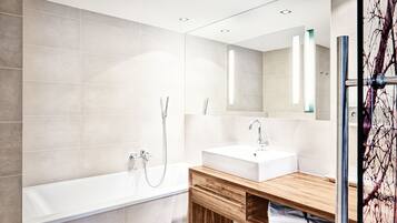 Ein modernes Badezimmer mit Badewanne, Waschbecken und Dusche.