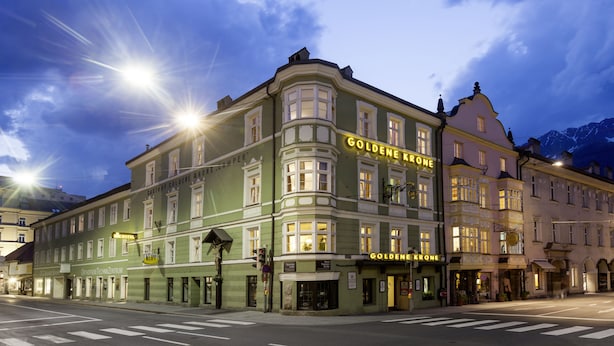 A historic building with multiple stories, featuring a prominent 'Golden Krone' sign, indicating a hotel. The architecture includes ornate detailing and large windows. - Hotel Goldene Krone (Innsbruck)