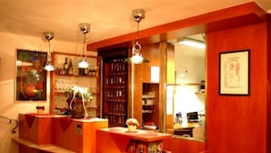 A bar area with wooden furniture, hanging lights, and a mirror reflecting the space. - Hotel Goldene Krone (Innsbruck)