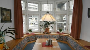 A corner seating area with a table, a lamp, and potted plants. - Hotel Goldene Krone (Innsbruck)