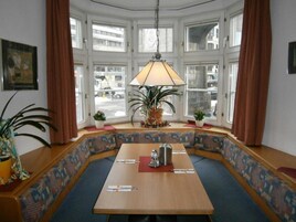 Un rincón amoblado con asientos, una mesa, una lámpara y plantas en macetas.