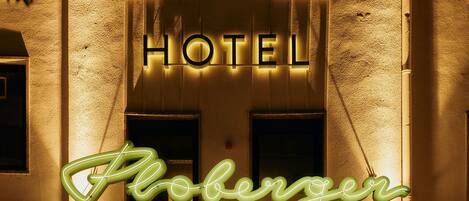 A hotel sign with the name "Hotel Floberger" illuminated in neon lights.
