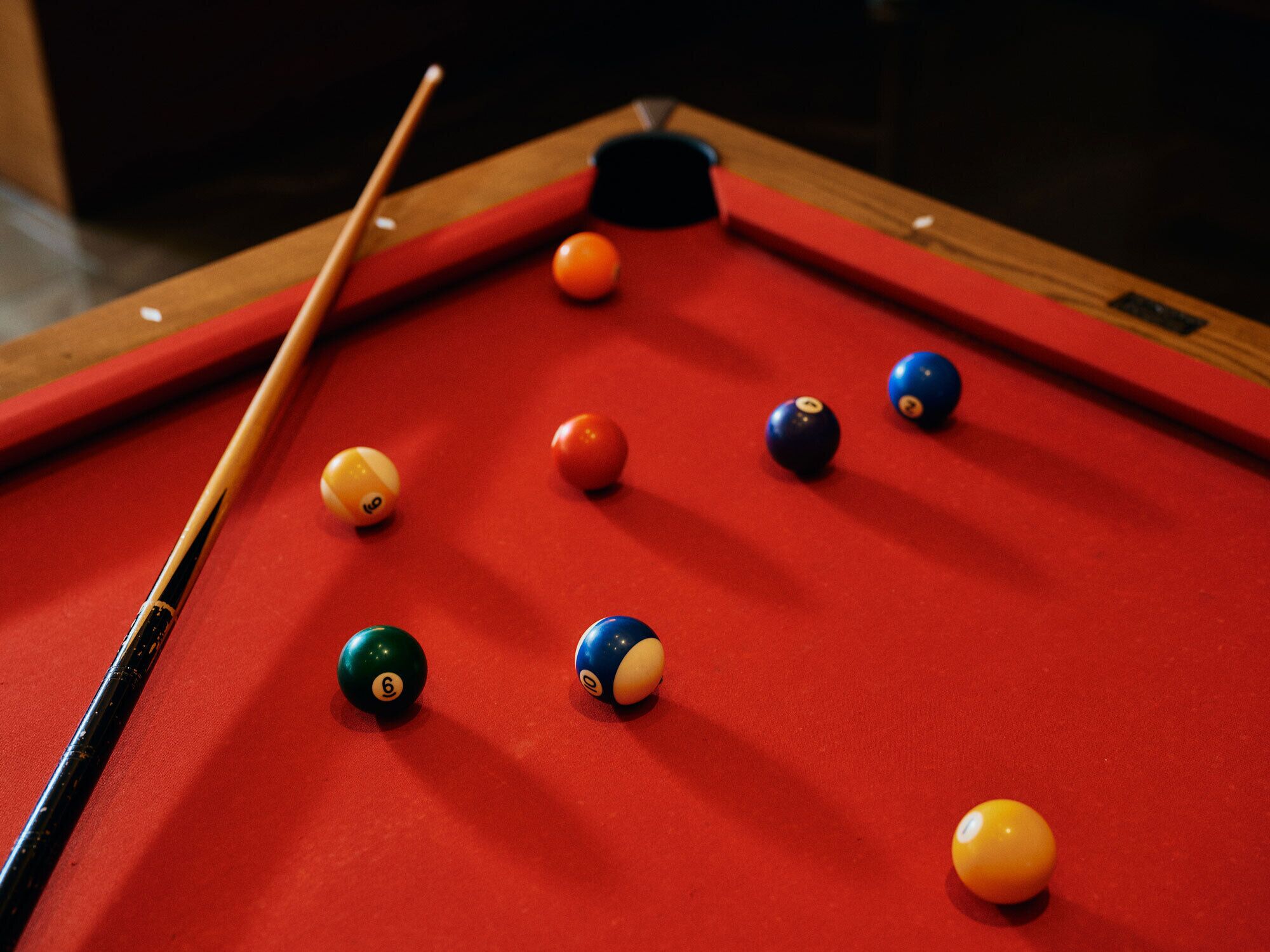 Een pooltafel met ballen en een keu.