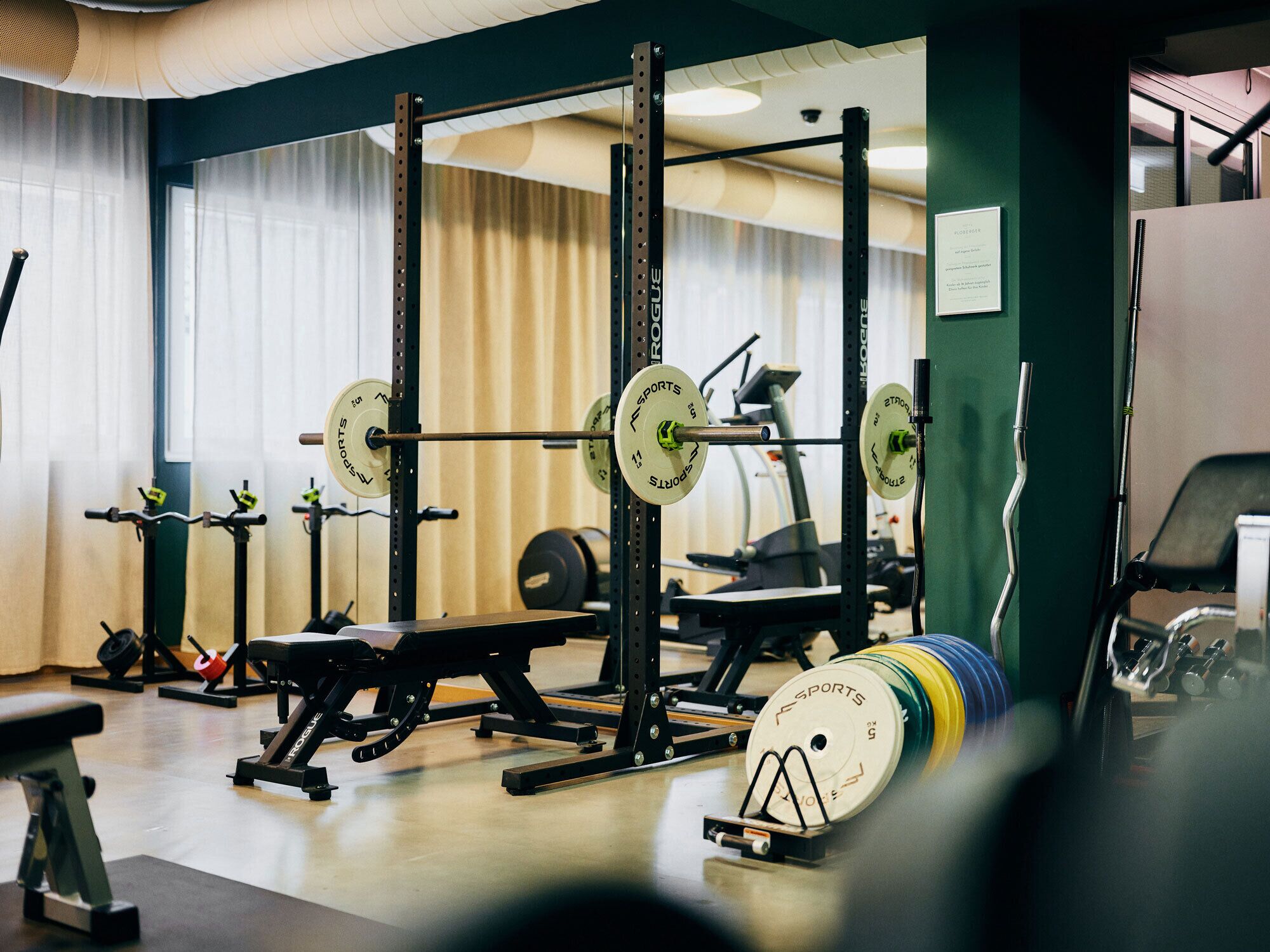 A gym with weightlifting equipment, including barbells and weight plates.