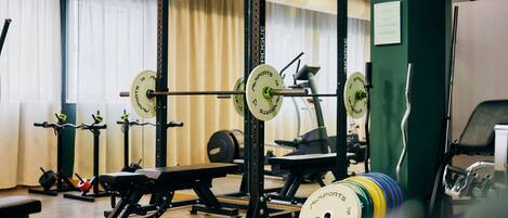 A gym with weightlifting equipment, including barbells and weight plates.