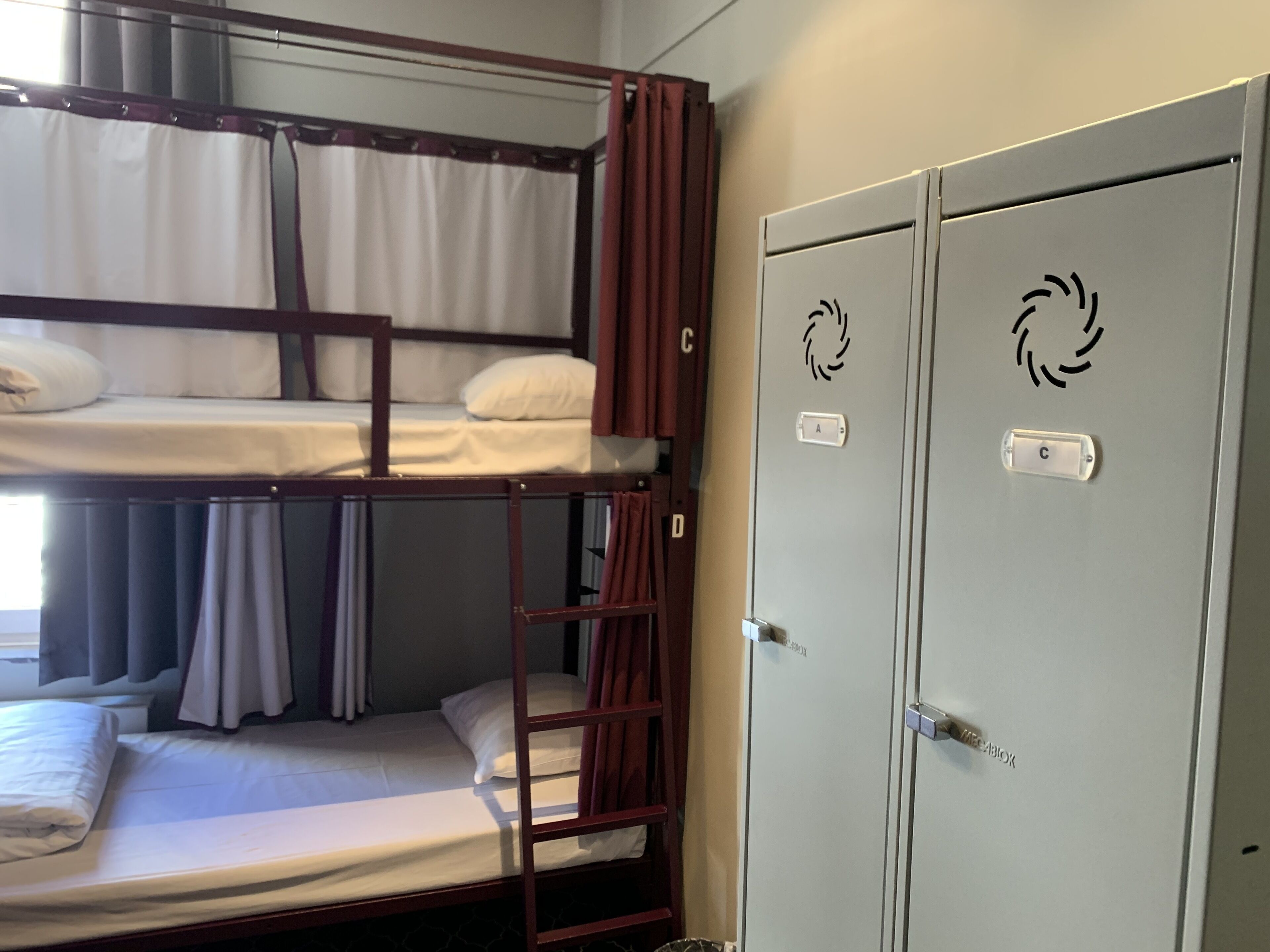A bunk bed room with a wardrobe and a door with a circular logo.