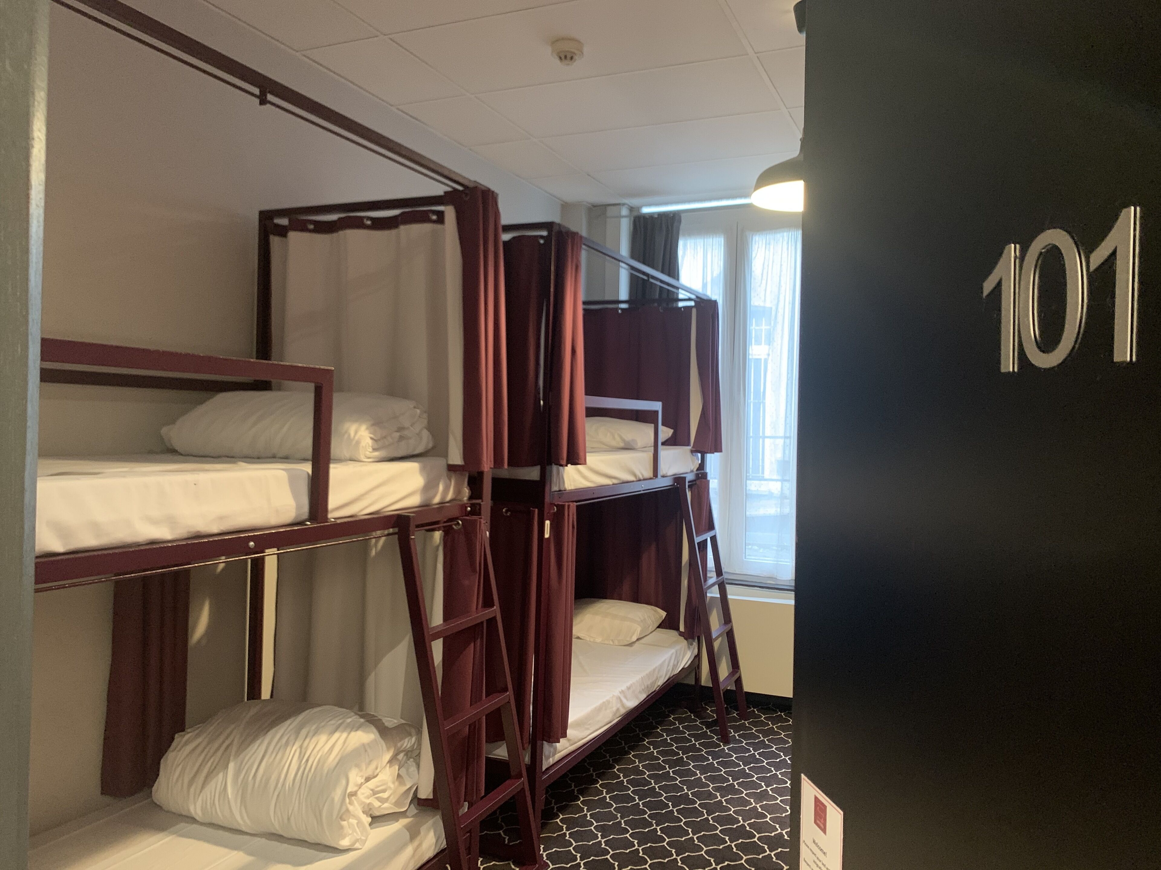 A room with bunk beds, a ladder, and a number '101' on the wall.